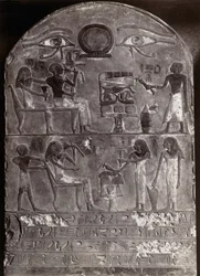 Baixo-relevo Olhos de Hórus: Baixo-relevo e hieróglifos numa estela arqueada com dois olhos de Hórus no topo. Arte Egípcia. Estela Museu do Louvre, A.G. Fotografia