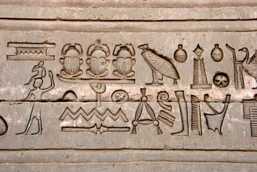 Antiquite egípcio: hieróglifos na parede oriental do templo de Hathor, Denderah, Egito
