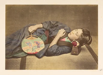 Japonesa dormindo, Retrato de estúdio de três quartos de uma jovem japonesa dormindo, segurando um ventilador na mão direita e com a cabeça apoiada em um travesseiro de madeira,   Fotógrafo: Desconhecido  Coleção Lucas: registro fotográfico do mundo t