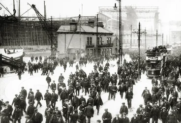 Hora de arrebentar no estaleiro Harland und Wolff, Belfast, Irlanda, com o Titanic em construção ao fundo, 1910-11