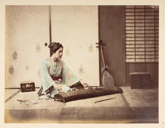 Meninas cantando [Japão], Retrato de estúdio de uma jovem japonesa sentada em um tatame tocando um instrumento de cordas,  Fotógrafo: Desconhecido  Coleção Lucas: Registro fotográfico da turnê mundial de Charles James e Morton P, Lucas