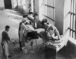 Uma Unidade de Cirurgia de Campo operando em uma prisão italiana sob fogo durante a Segunda Guerra Mundial, de uma coleção de 650 fotografias compiladas pela Associação de Comando.