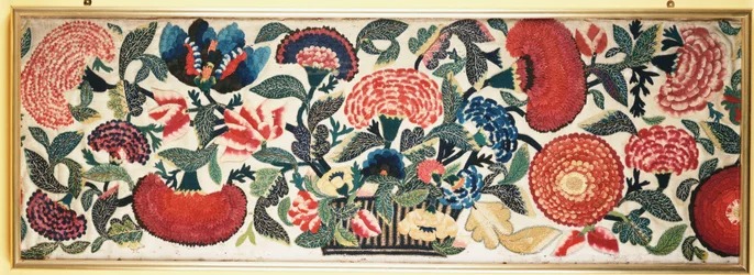 Um painel de feltro e apliques com destaques de seda bordados representando cravos, tulipas e outras flores transbordando de uma cesta contra um chão de lã de marfim, c.1730-40