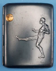 Cigarreira com um jogador de futebol chutando uma bola de ouro no ar. c.1880 (metal)