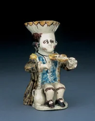 Jarro Toby do violinista, o chapéu com bordo recortado castanho e amarelo, o cabelo castanho inciso e preso em rabicho com uma roseta branca, com uma sobrecasaca em aguada castanha, c. 1770