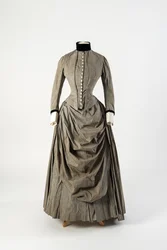 Vestido de algodão cinzento com frente de avental drapeada e guarnição de veludo preto na gola e nos punhos, finais da década de 1880