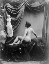 Senhora nua a admirar a figura da Vénus de Milo (fotografia a preto e branco)