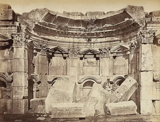 Detalhe das chamadas "salas" na zona arqueológica de Heliópolis ou Baalbek, antiga cidade síria, hoje Líbano. Um homem posa, sentado sobre as ruínas.