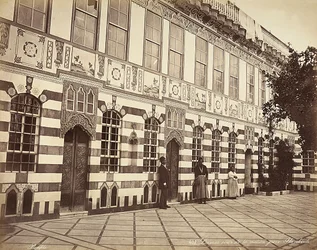 O pátio de uma casa judaica em Stambouli, na Síria, Três domésticos são mostrados perto das paredes do edifício