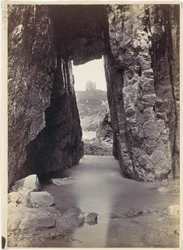 Vista através de rochedos de uma torre numa colina