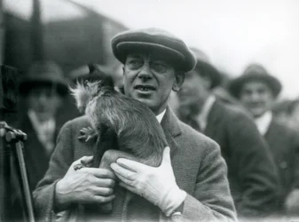 Um Mangabey de crista preta, possivelmente Freckles, com seu manipulador, participando de uma transmissão externa do zoológico de Londres, 1925