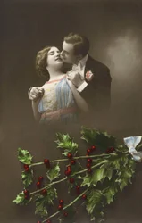 Um casal apaixonado e ramos de azevinho. Cartão postal do início do século XX