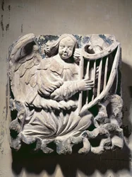 Músico de anjo tocando a harpa (baixo-relevo)