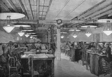 Sala de telegrafia feminina no escritório central do Ministério dos Correios e Telégrafos iluminada com luz elétrica por lâmpadas de arco voltaico (sistema cancele), Paris 1883.