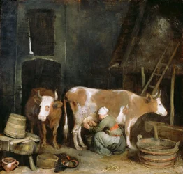 Uma empregada ordenha uma vaca em um celeiro