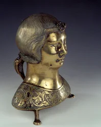 Aquamanile (bacia para lavar as mãos do padre durante a missa) em bronze dourado na forma do busto de um jovem. 1300-1325. De Hildesheim. Sol 0,23x0,19 m Paris, museu nacional da Idade Média, Termas de Cluny.