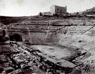 Os restos do Teatro Grego em Siracusa, no Parque Monumental do Neápoll. Em primeiro plano, a orquestra semicircular e a caverna
