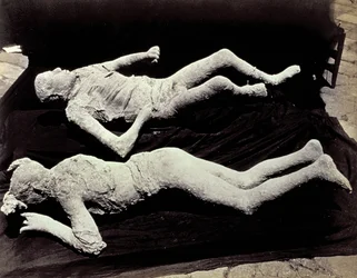 Dois elencos de figuras humanas das escavações de Pompeia. As peças foram colocadas em tecido preto para fotografá-las.