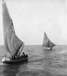 Barcos à vela com pessoas a bordo