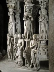 Detalhe dos grupos esculpidos de apoio à Cadeira realizados por Giovanni Pisano (1248-1314): a Igreja alimenta seus filhos e duas das quatro virtudes cardeais (Detalhe das esculturas de apoio ao púlpito de mármore, a Igreja alimenta seus filhos e duas card