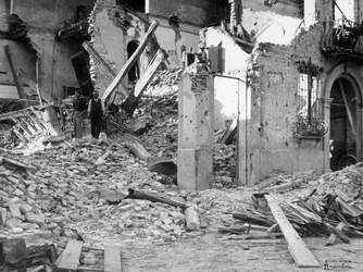 Os bombardeamentos do Sermide. Duas pessoas entre os escombros de um edifício destruído...