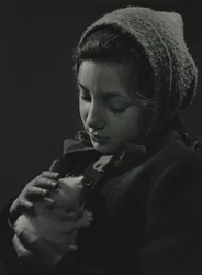 Rapariga com um gatinho branco nos braços. Início da década de 1950