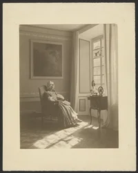 [Interior com mulher sentada em traje].