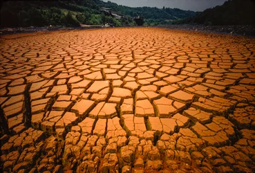 O leito de uma lagoa é deixado a descoberto depois de ter sido poluído pelo ácido de uma mina de carvão e outros resíduos....