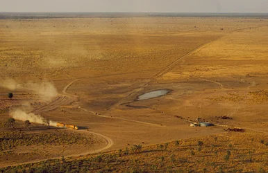 Comboio rodoviário que transporta gado atravessa um planalto proibitivo do outback. Austrália Ocidental, Austrália.