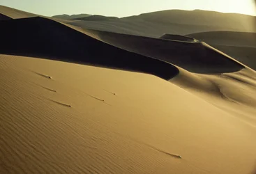Vista de dunas de contornos nítidos e sombreados perto de Dunhuang. Província de Gansu, República Popular da China.