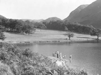 Uma família à beira do lago a pescar e a olhar para a água
