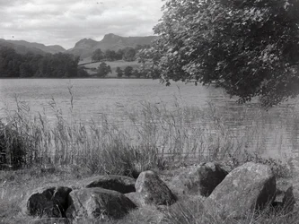 Vista de Loughrigg Tarn, em primeiro plano estão algumas pedras colocadas no chão