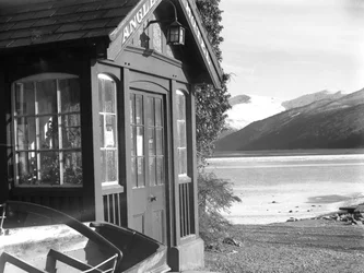 Vista de uma entrada para o "Anglers Hotel", com o lago e as montanhas à direita da imagem