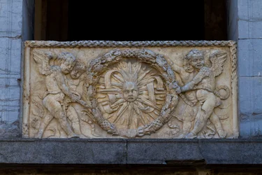 Placa de balaustrada com sol radiante em grinalda, baixo relevo na fachada da igreja de San Sebastiano