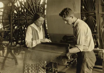 Um rapaz e uma rapariga a trabalhar num tear na fábrica de seda Cheney Silk Mills em South Manchester, Connecticut