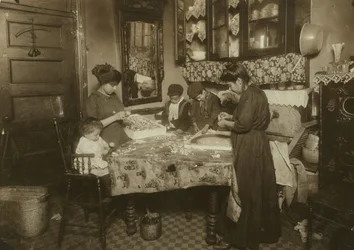 A Sra. Mette e seus filhos (Josephine 13, Nicholas 6 e Johnnie 8 ganham apenas 40-50 centavos por dia) fazendo flores em um prédio sujo de Nova York, 1911