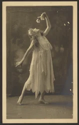 [Bailarina com flor diante de uma tapeçaria]