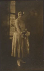 [Retrato de corpo inteiro de uma mulher a segurar um ramo de flores]