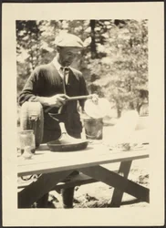 Homem de pé junto a uma mesa de piquenique
