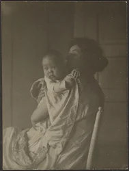 [Mãe segurando o bebé na cadeira].