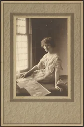 [Retrato de uma mulher a olhar para um álbum].
