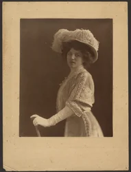 [Retrato de uma mulher de pé com um guarda-chuva].
