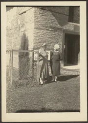 [Duas mulheres antes do edifício].