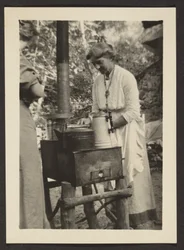 [Mulher a utilizar o fogão de exterior].