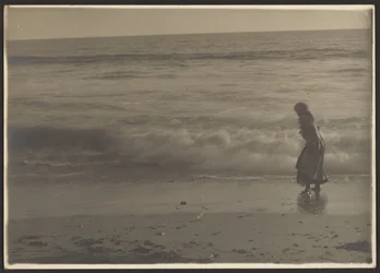 Mulher a caminhar na rebentação na praia