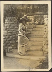 [Mulher com câmara nos degraus].