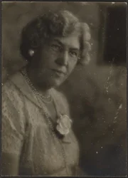 Mulher com flor branca e pérolas
