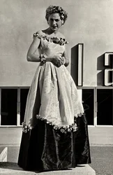 Modelo em vestido de baile criado pela casa de alta costura "Graldi". O artigo é caracterizado por uma linha de pescoço baixa e saia cheia decorada com apliques florais. (foto a p/b)