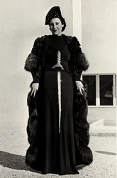 Modelo em vestido de noite criado pela casa de alta costura italiana "Dragoni". A fonte do artigo tem uma decoração de lantejoulas brilhantes em forma de espada. Um chapéu e um sobretudo de pele completam o conjunto. (foto a p/b)