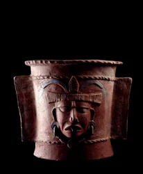 Arte pré-colombiana, civilização maia, período clássico tardio: urna funerária cilíndrica de barro decorada com um rosto humano. Proveniente de Quiché, Guatemala. Dimensões: altura 38.5 x diâmetro 39,5 cm. Guatemala, Museu Nacional de Arqueologia e